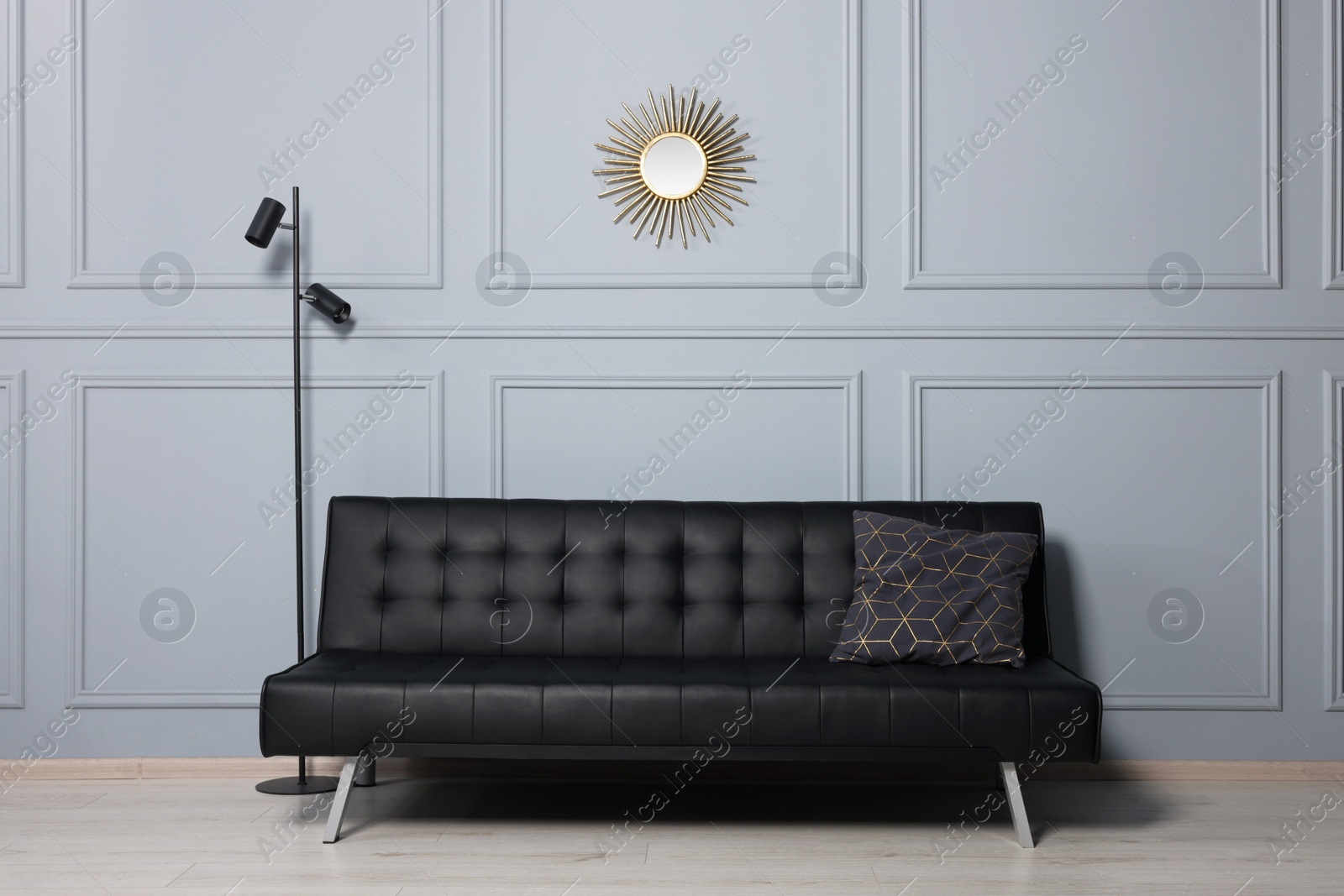 Photo of Stylish room interior with comfortable leather sofa and floor lamp