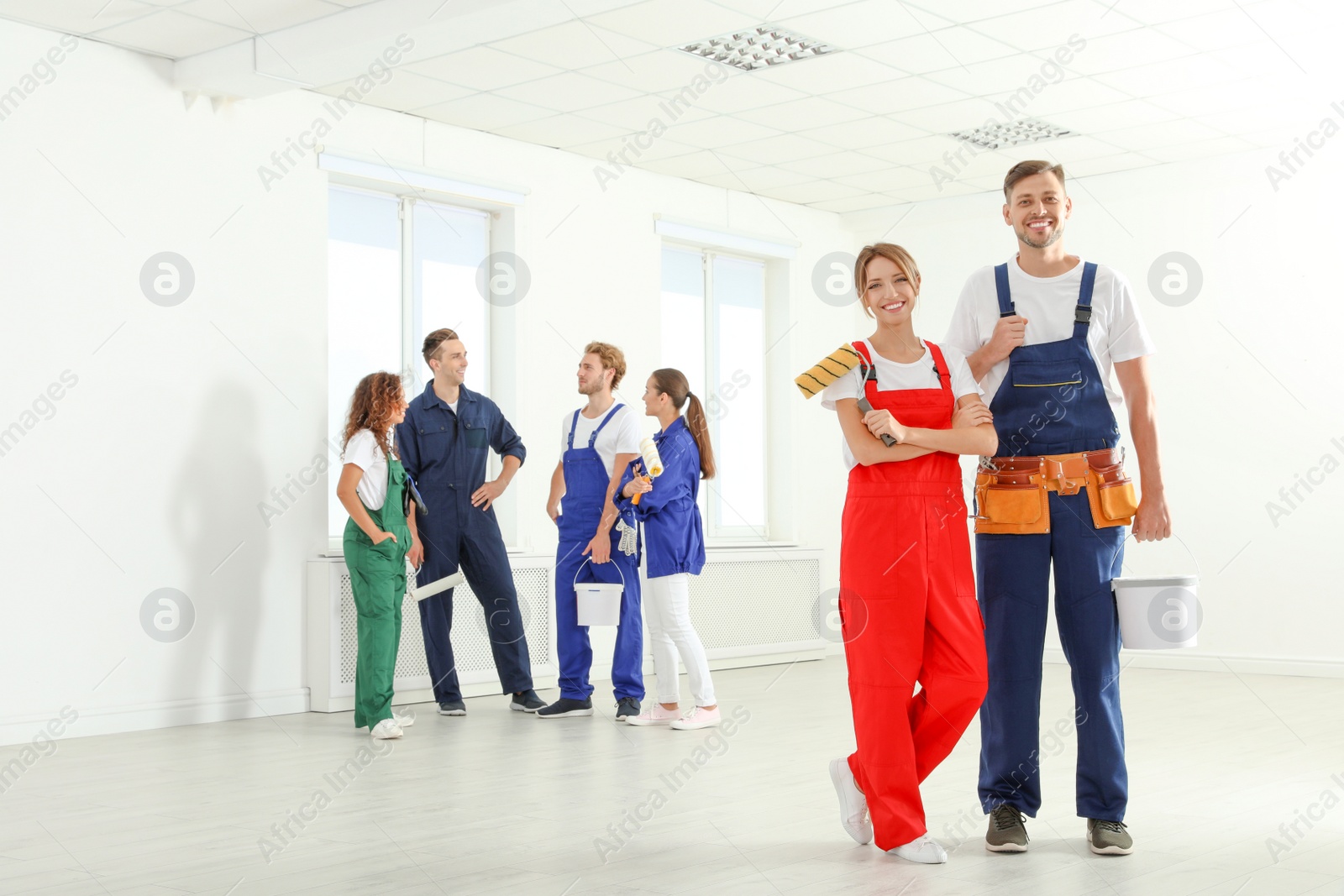 Photo of Team of professional painters with tools working indoors