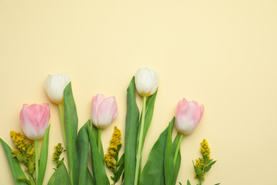 Photo of Flat lay composition with spring flowers on yellow background. Space for text