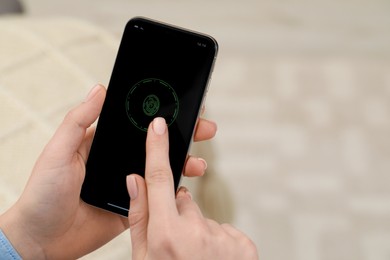 Woman unlocking smartphone with fingerprint scanner indoors, closeup. Space for text