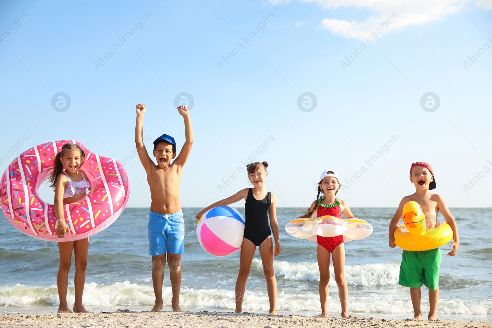 Photo of Cute children enjoying sunny day at beach. Summer camp