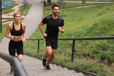 Photo of Healthy lifestyle. Happy couple running up stairs outdoors, space for text