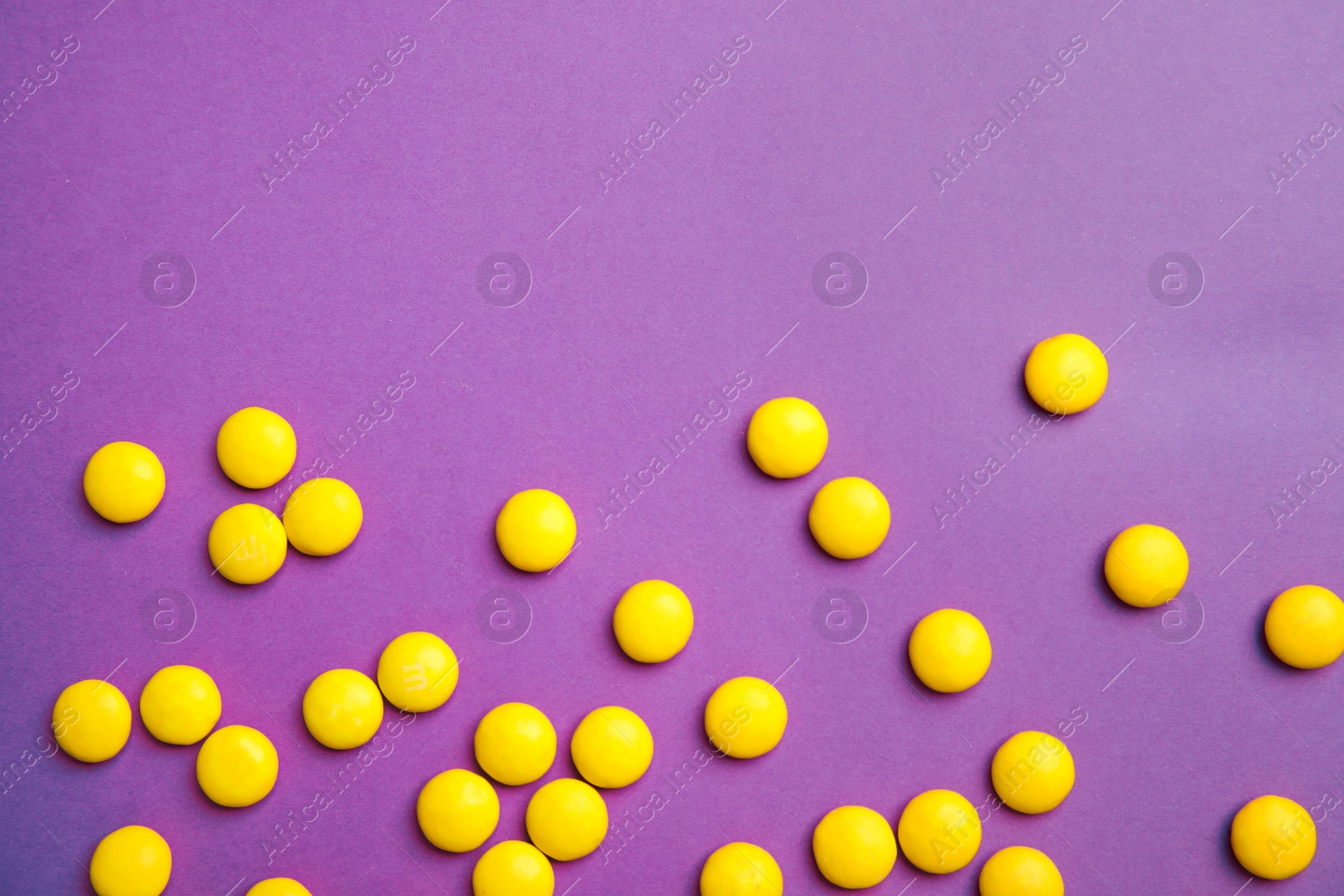 Photo of Tasty glazed candies on color background, top view. Space for text