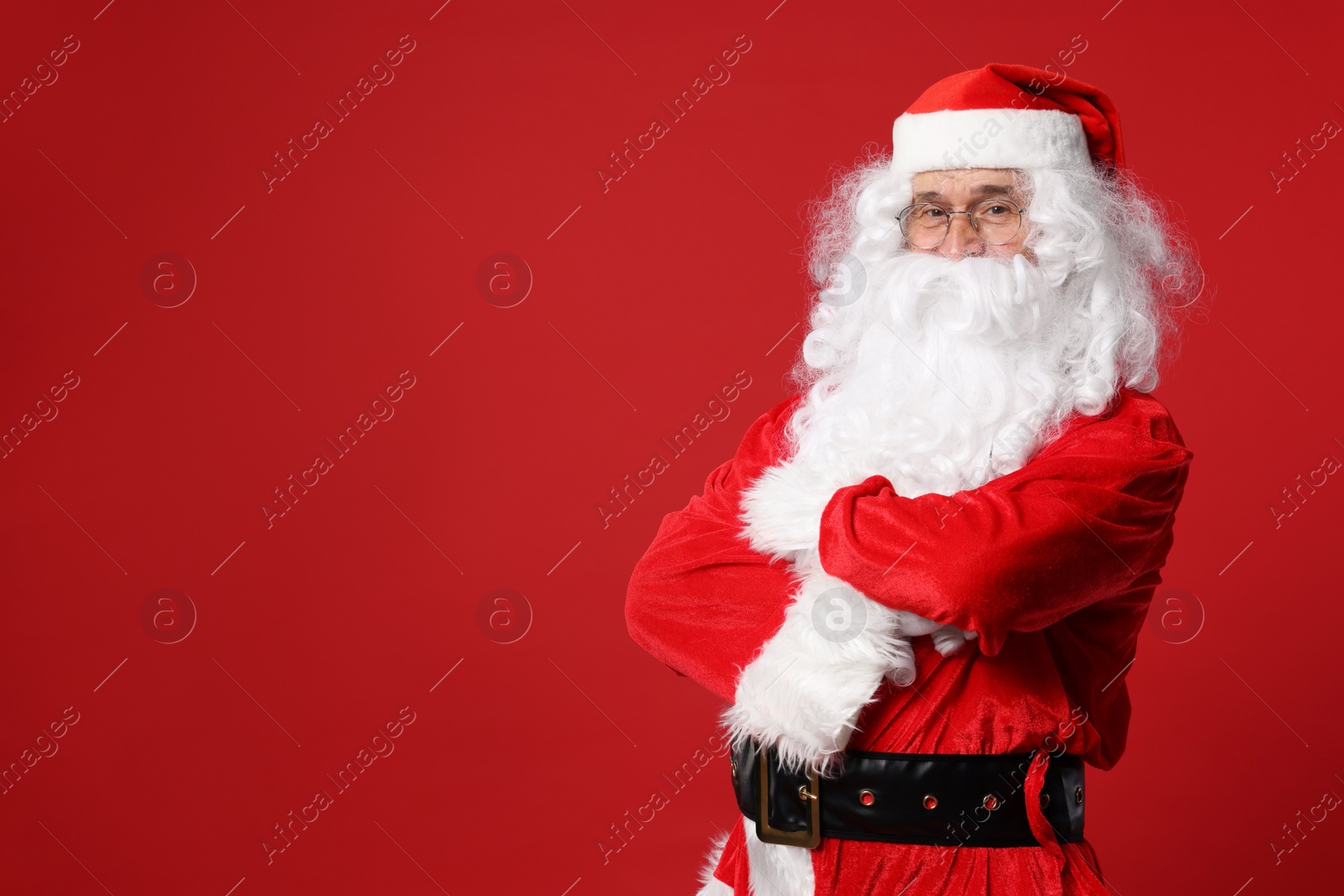 Photo of Merry Christmas. Santa Claus posing on red background, space for text