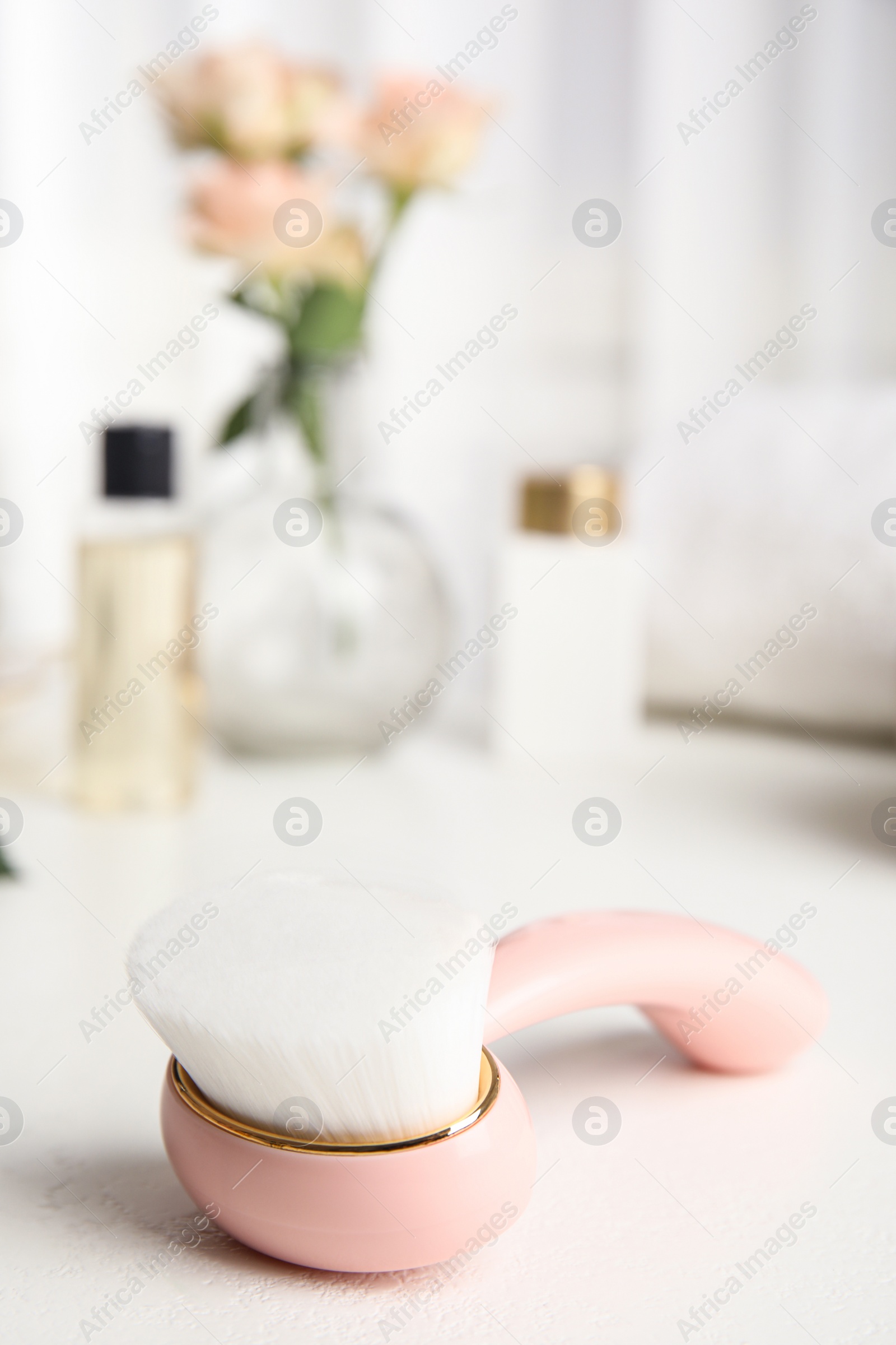 Photo of Stylish face cleansing brush on white table. Cosmetic accessory