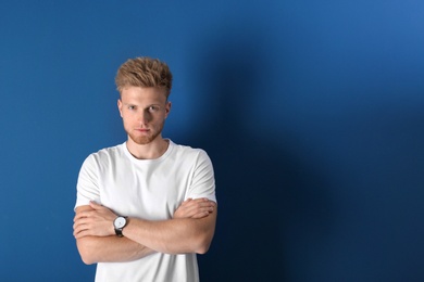 Photo of Portrait of handsome young man on blue background. Space for text