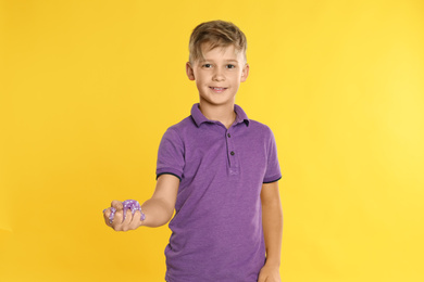 Photo of Preteen boy with slime on yellow background