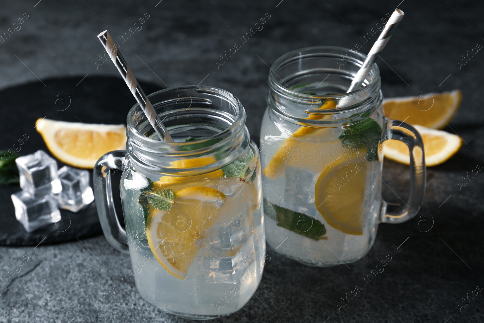 Photo of Delicious lemonade in mason jars on grey table