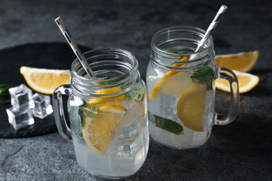 Delicious lemonade in mason jars on grey table