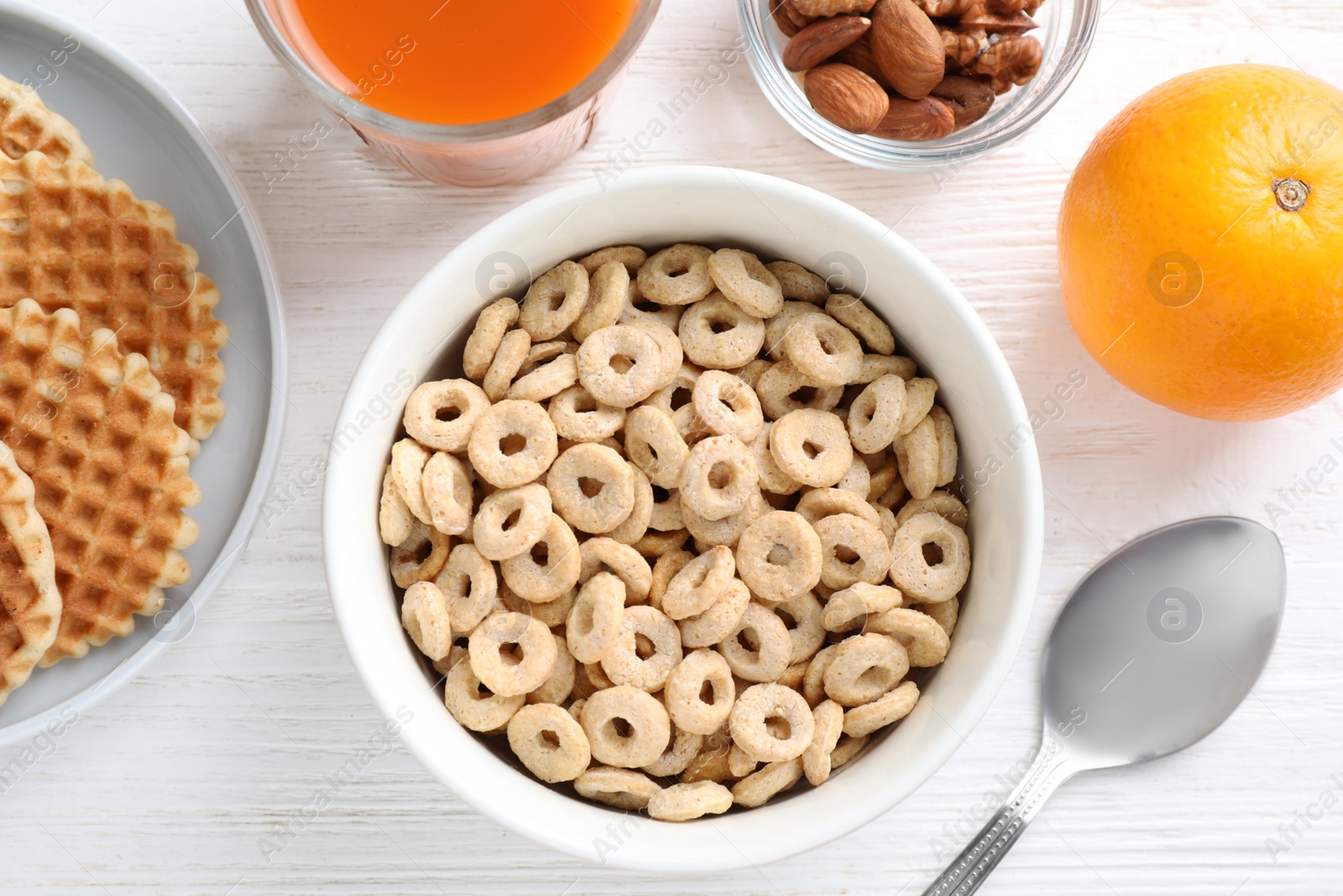 Photo of Flat lay composition with corn rings on white wooden table. Healthy breakfast