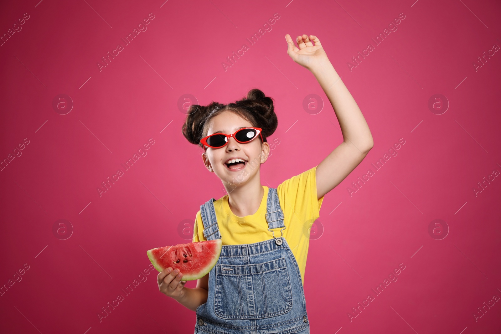 Photo of Cute little girl with watermelon on pink background