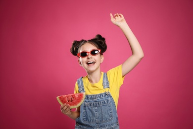 Cute little girl with watermelon on pink background