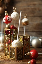 Composition with delicious Christmas ball cake pops on wooden table