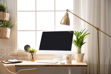 Photo of Light work place with computer near window at home. Interior design