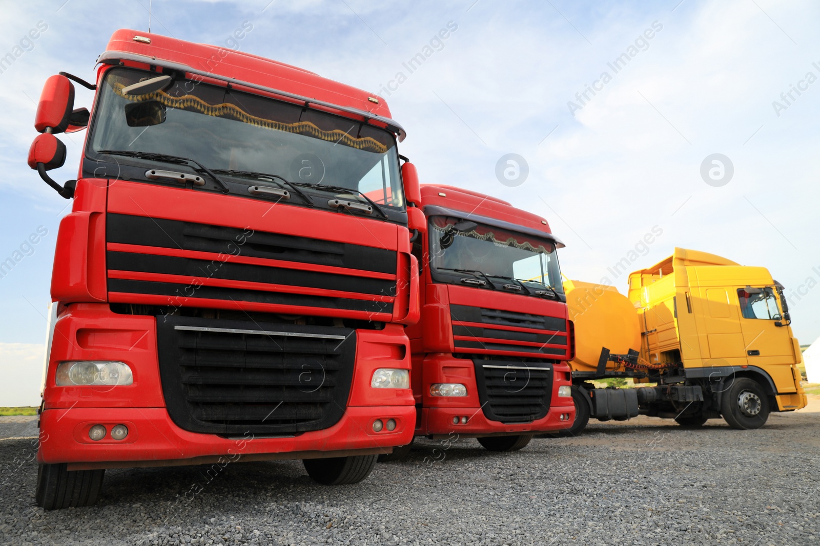 Photo of Different bright trucks parked outdoors. Modern transport