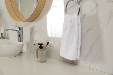 Soft towel on wall above bathroom countertop with toiletries