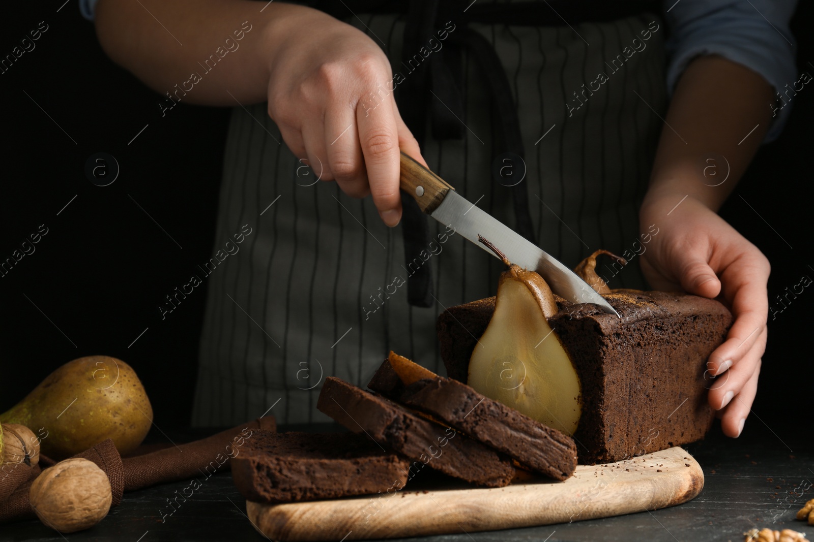 Photo of Woman cutting tasty pear bread at table, closeup. Homemade cake