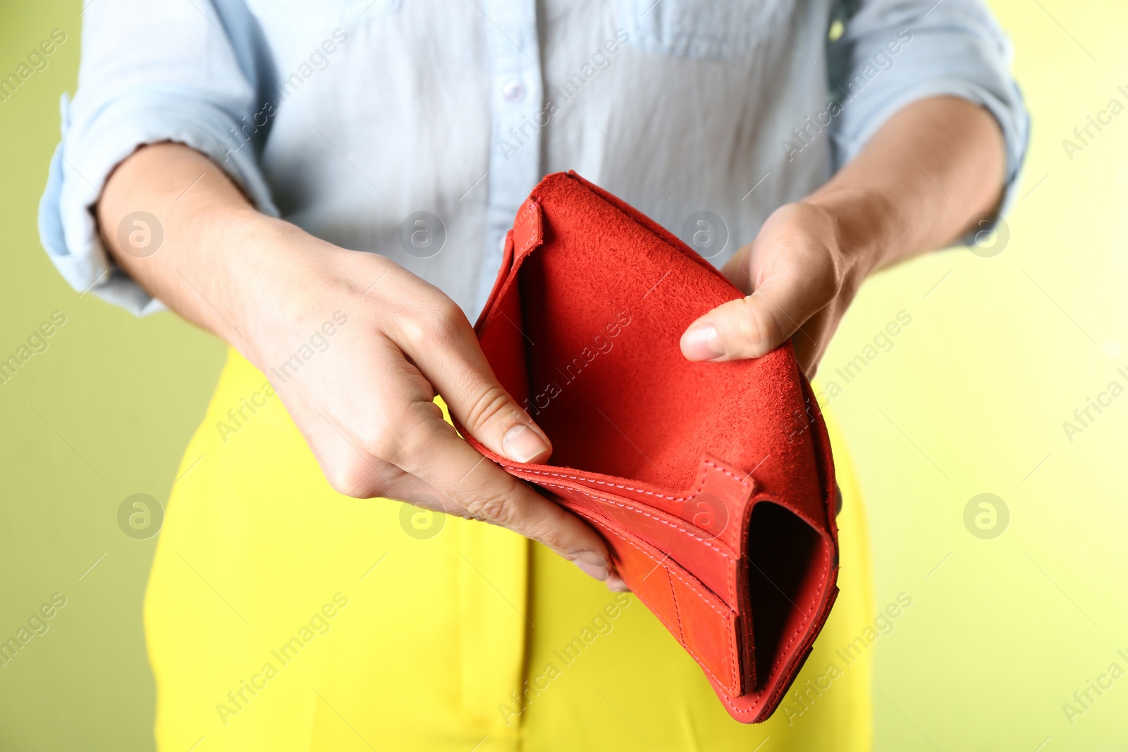 Woman showing empty wallet on light green background, closeup Photo of Woman showing empty wallet on light green background, closeup