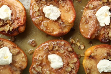 Tasty baked quinces with nuts and cream cheese in dish, top view