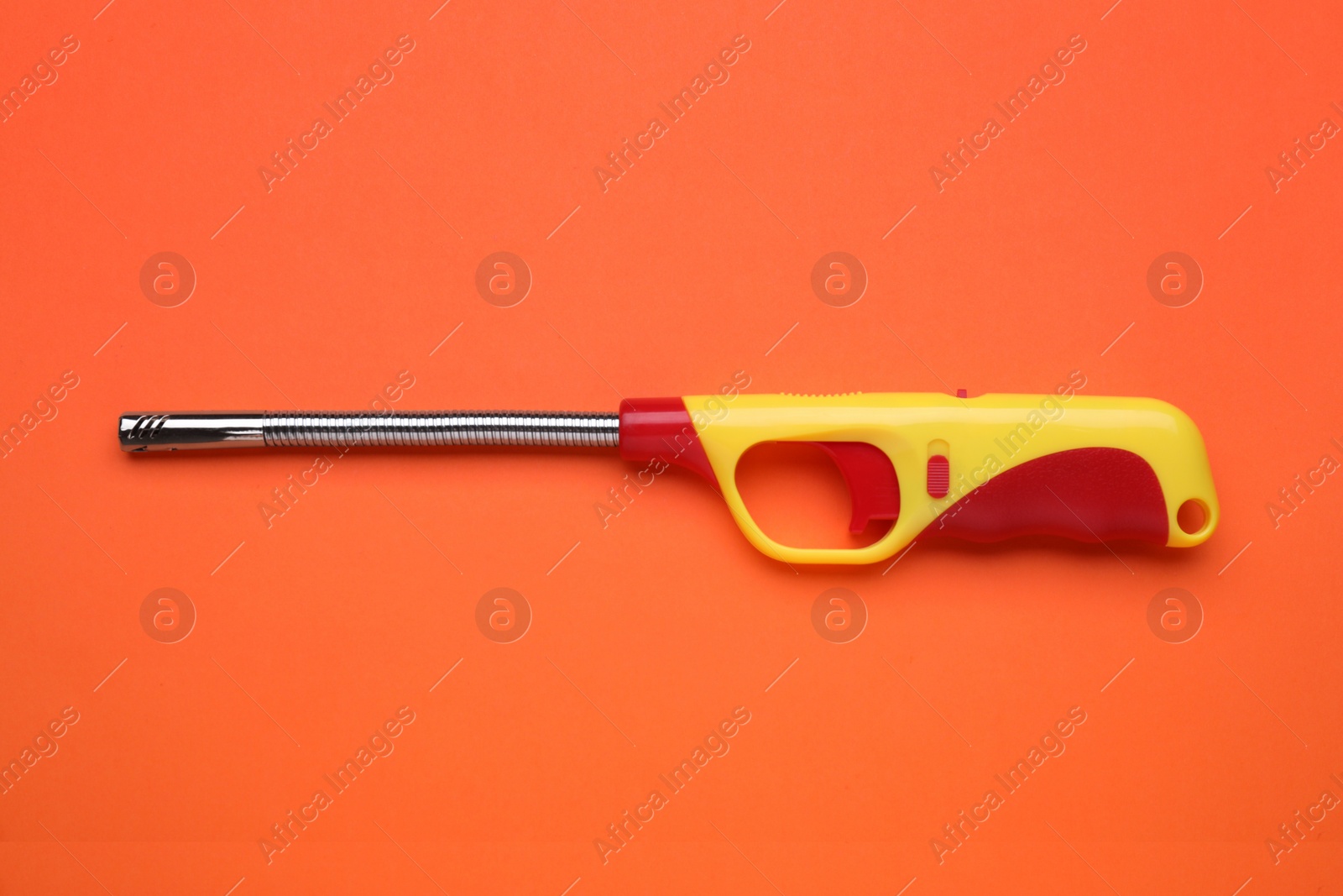 Photo of One gas lighter on orange background, top view