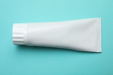 Photo of Blank tube of toothpaste on color background, top view