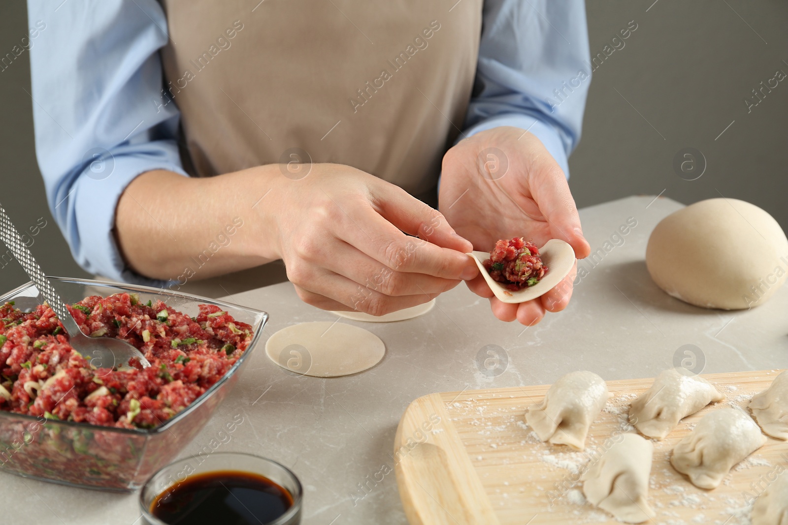 Photo of Woman making gyoza at light table, closeup