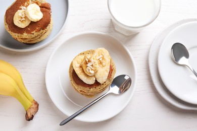 Photo of Banana pancakes served on white wooden table, flat lay