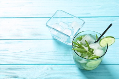 Photo of Natural lemonade with cucumber in glass on wooden table