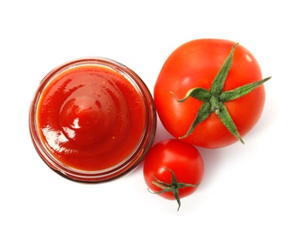 Photo of Tasty homemade tomato sauce in glass jar and fresh vegetables on white background, top view