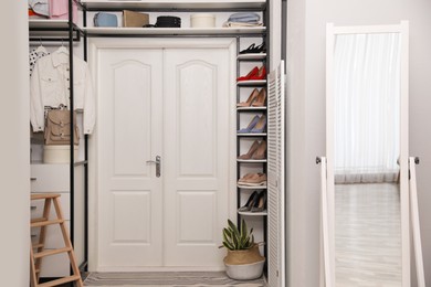 Photo of Closet interior with storage rack for shoes, clothes and accessories