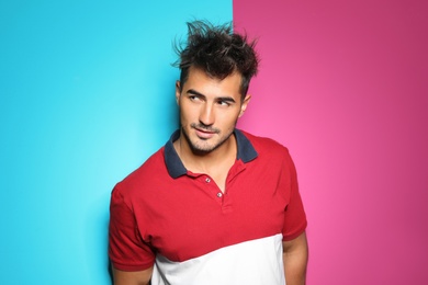 Photo of Young man with trendy hairstyle posing on color background