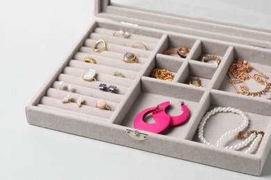 Photo of Jewelry box with many different accessories on light background, closeup
