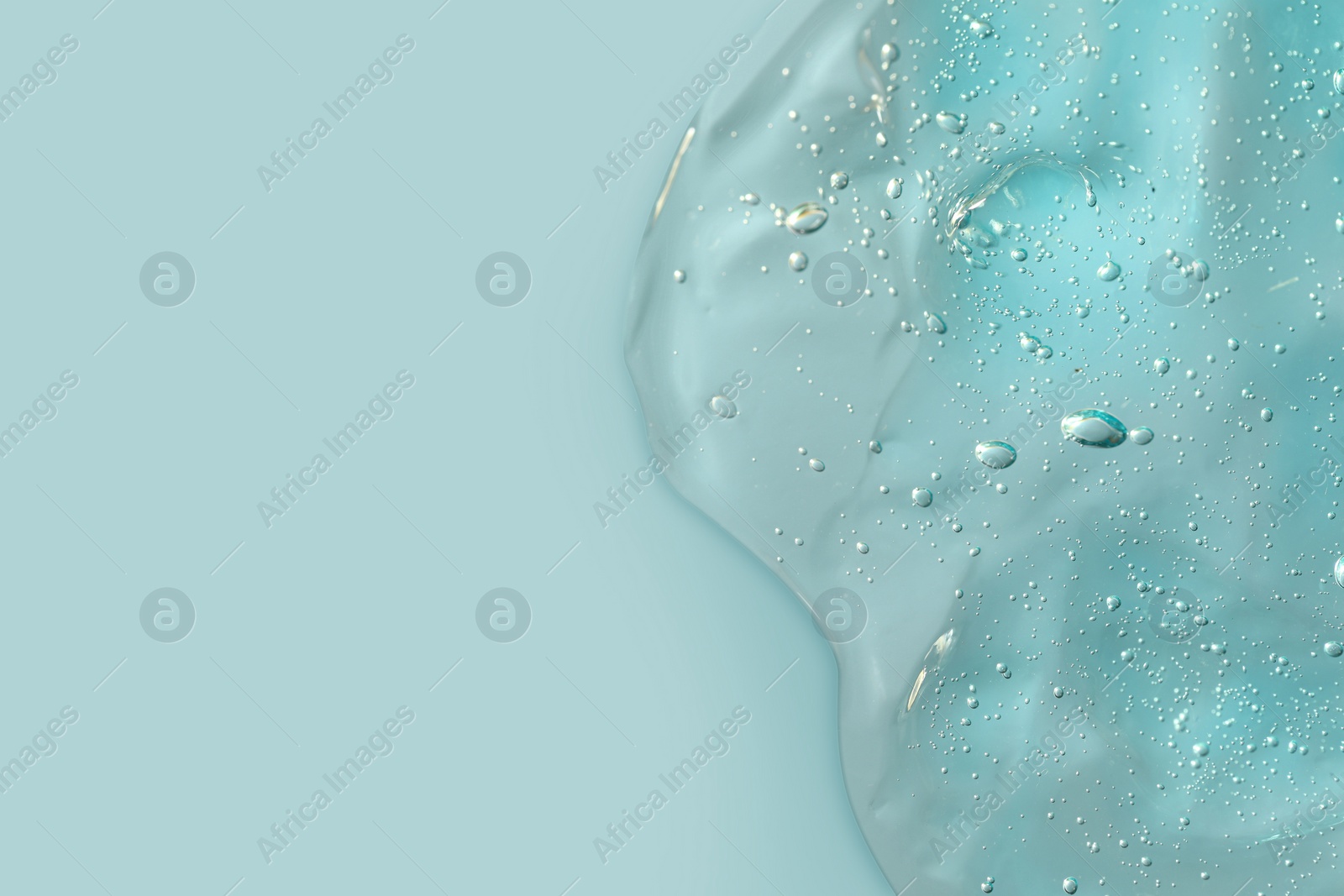 Photo of Transparent cleansing gel on light blue background, top view with space for text. Cosmetic product