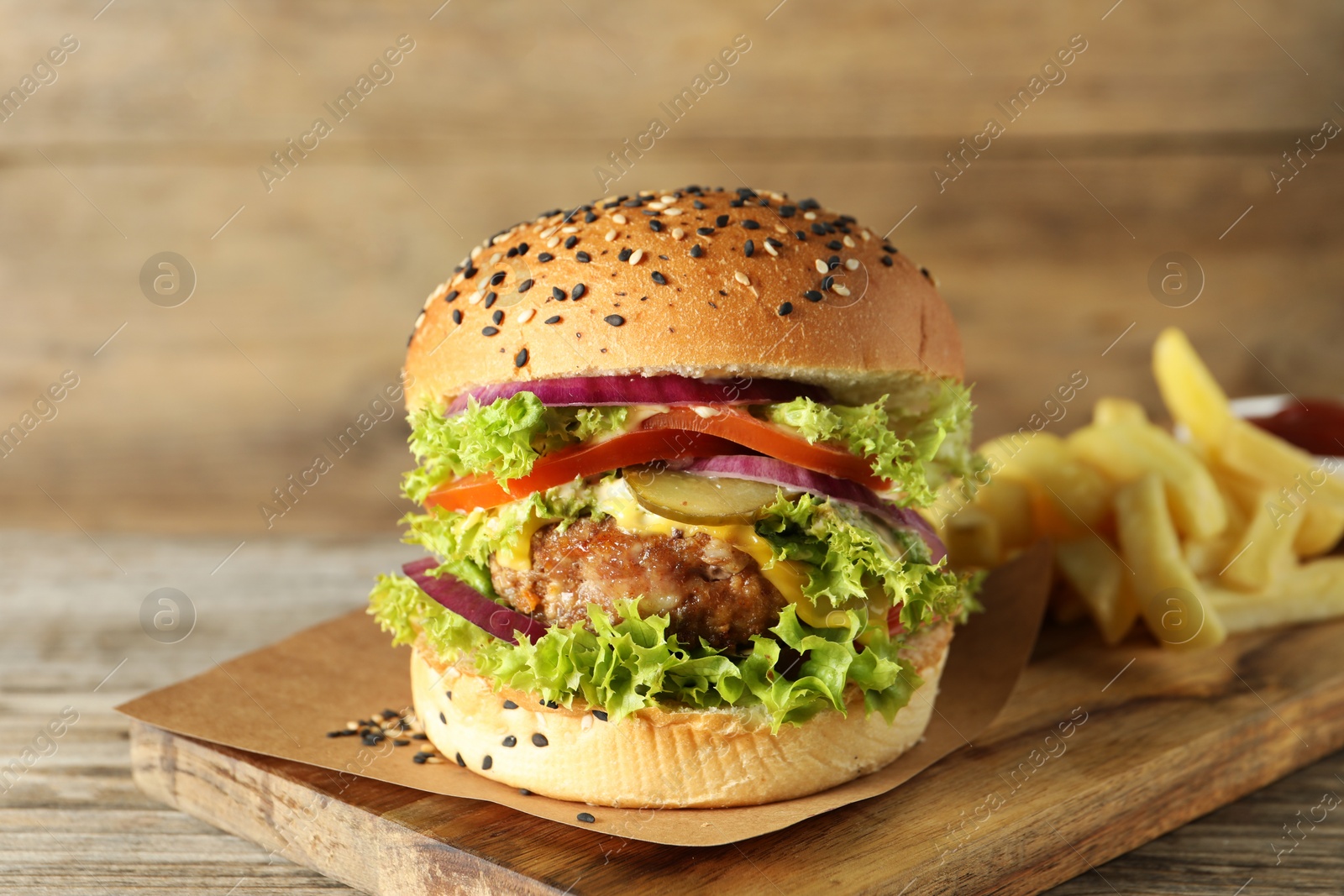 Burger with delicious patty and french fries on wooden table, closeup Photo of Burger with delicious patty and french fries on wooden table, closeup