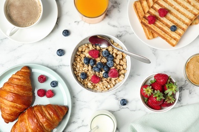 Tasty breakfast served on white marble table, flat lay