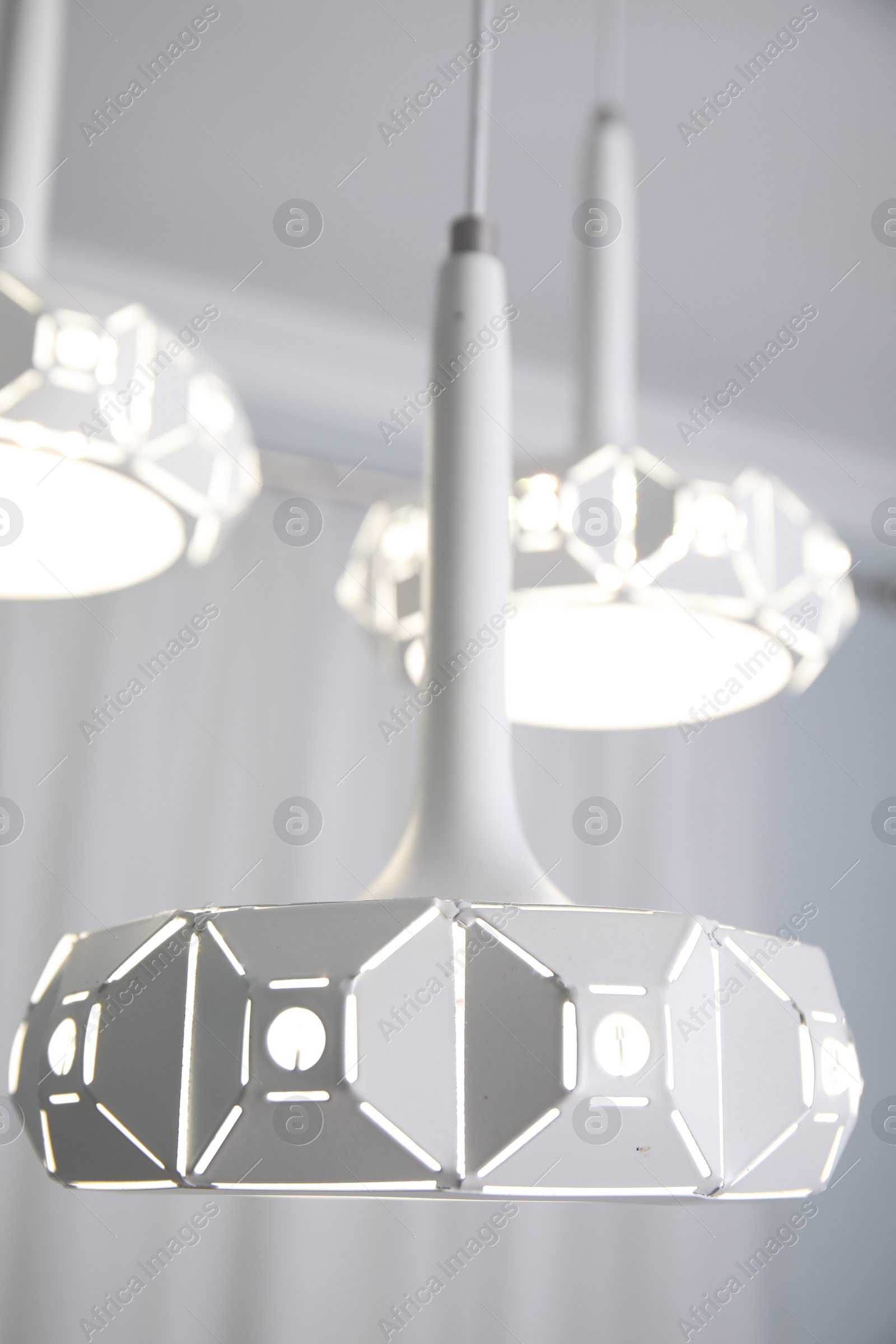 Photo of Stylish pendant lamp on white ceiling indoors