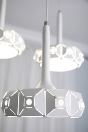 Photo of Stylish pendant lamp on white ceiling indoors