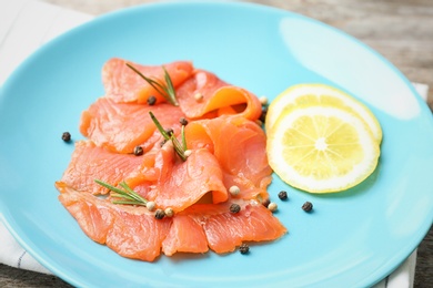 Photo of Plate with fresh sliced salmon fillet, lemon and pepper mix, closeup