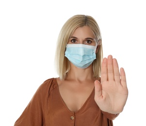 Photo of Woman in protective mask showing stop gesture on white background. Prevent spreading of coronavirus