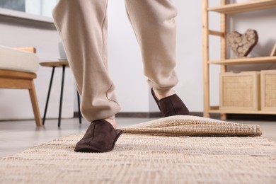 Man tripping over rug at home, closeup