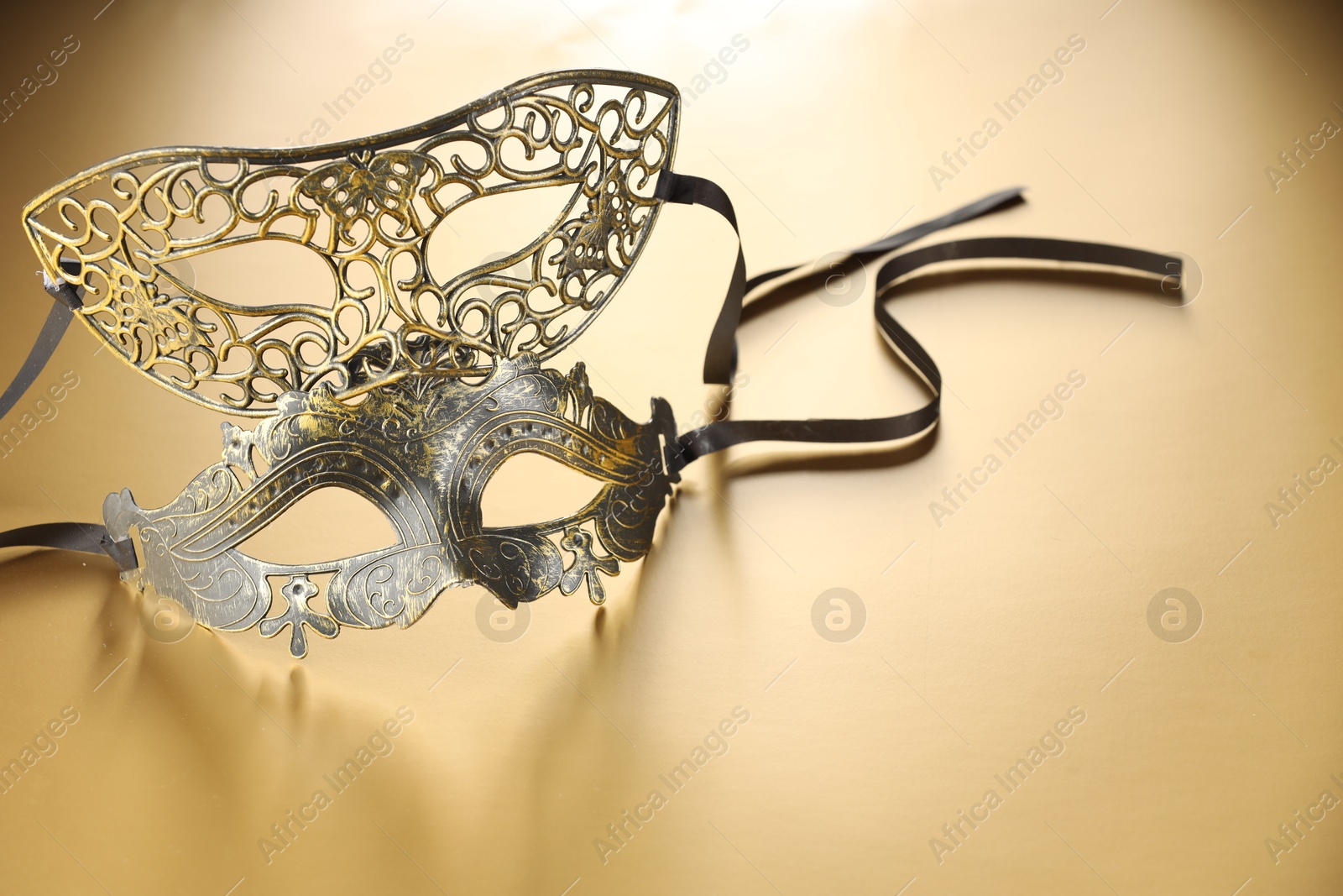 Photo of Elegant face masks on beige background, space for text. Theatrical performance