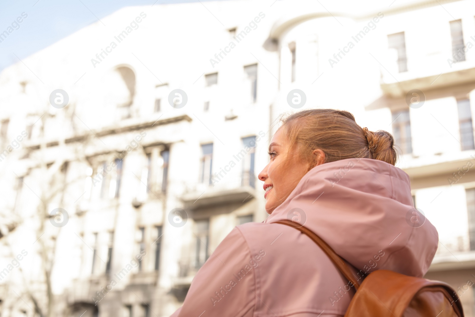 Photo of Young woman with backpack on city street