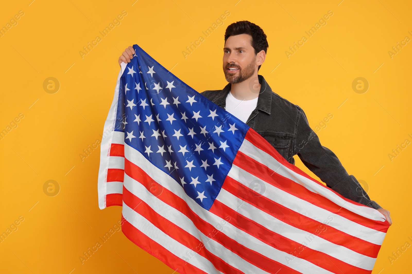 Photo of 4th of July - Independence Day of USA. Happy man with American flag on yellow background