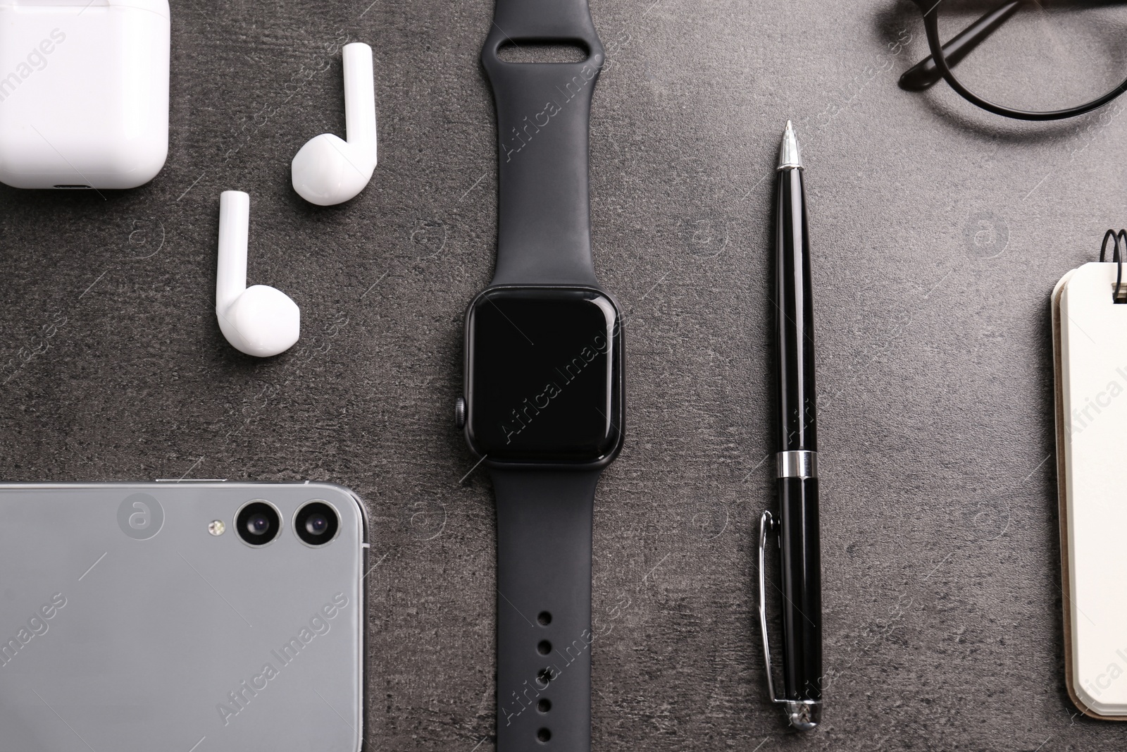 Flat lay composition with stylish smart watch on grey stone table Photo of Flat lay composition with stylish smart watch on grey stone table