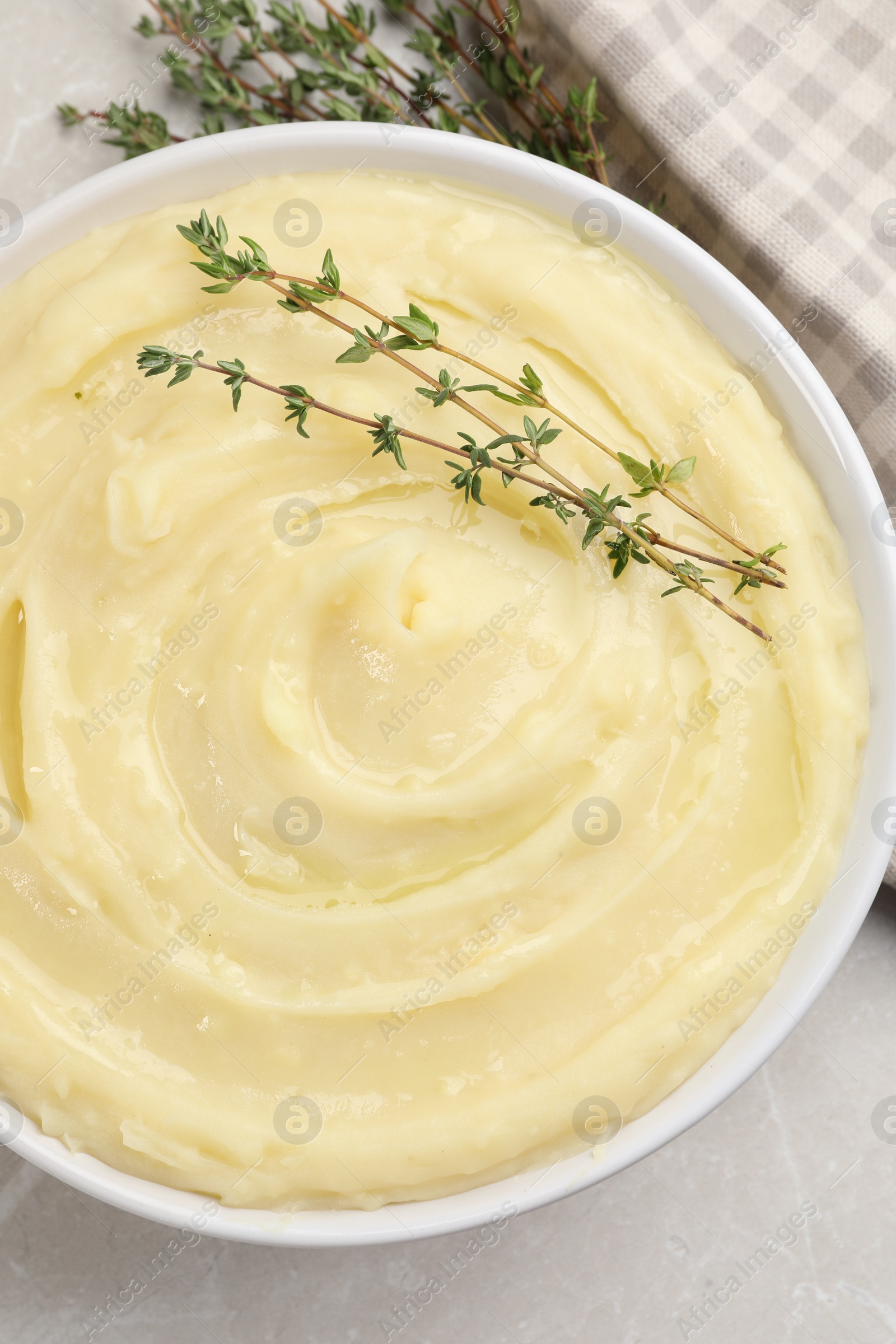 Photo of Bowl of tasty mashed potato with rosemary on grey marble table, flat lay