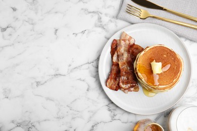 Photo of Delicious pancakes with maple syrup, butter and fried bacon on white marble table, flat lay. Space for text