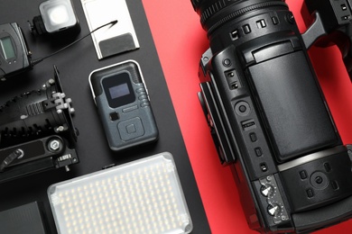 Photo of Flat lay composition with camera and video production equipment on color background