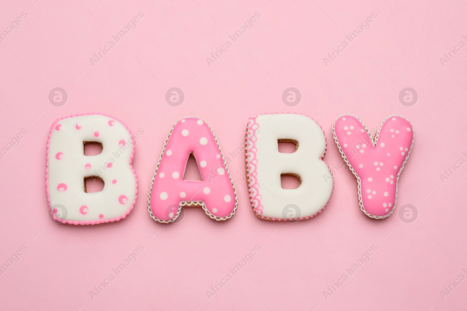 Photo of Word BABY made of tasty cookies on pink background, flat lay