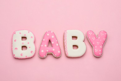 Photo of Word BABY made of tasty cookies on pink background, flat lay