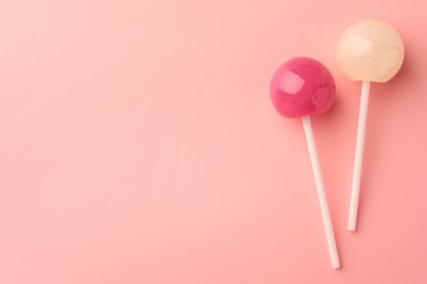 Tasty lollipops on pink background, flat lay. Space for text